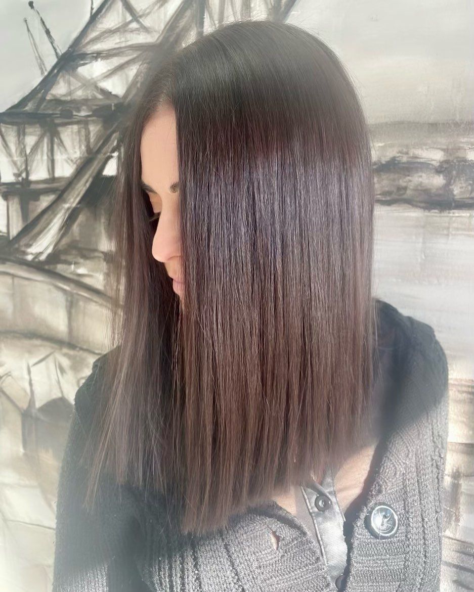 A Woman Is Getting Her Hair Cut In Front Of A Painting — Genesis Hair and Beauty In Port Kembla, NSW 