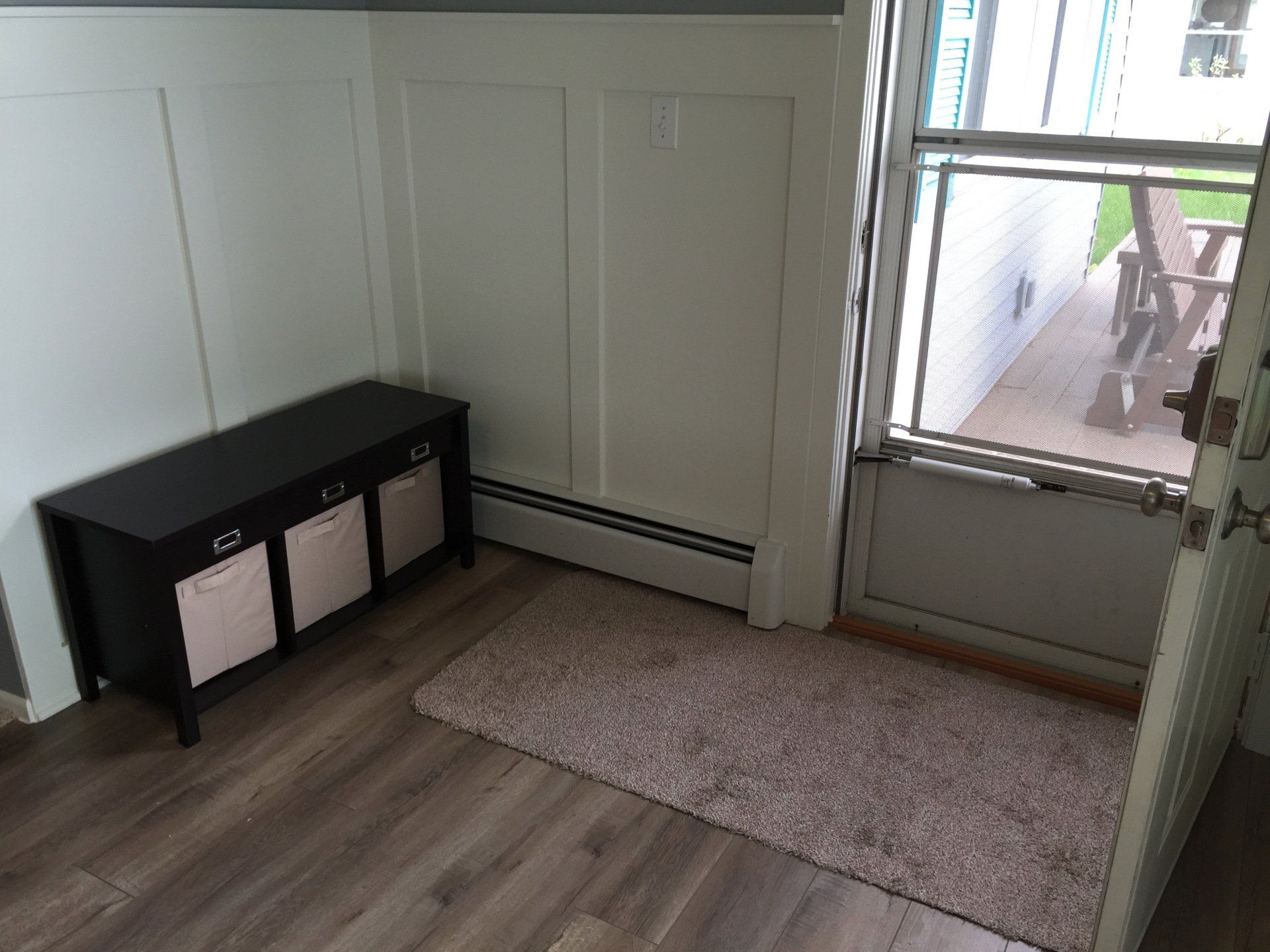 There is a bench in the corner of the room next to the door.