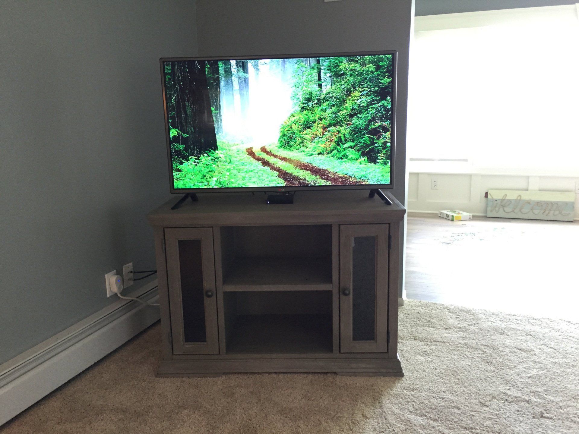 A flat screen tv is on a stand in a living room