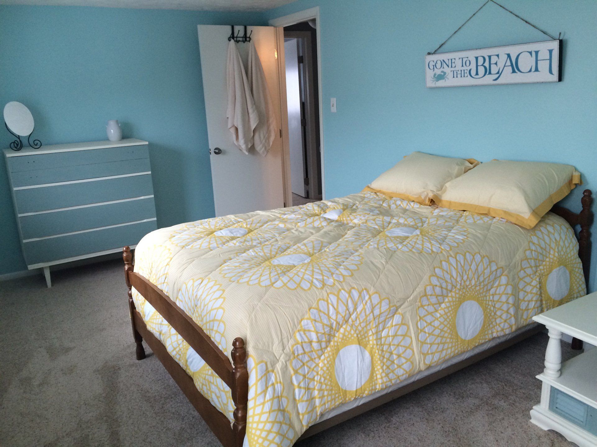 A bedroom with a bed and a sign that says i love the beach