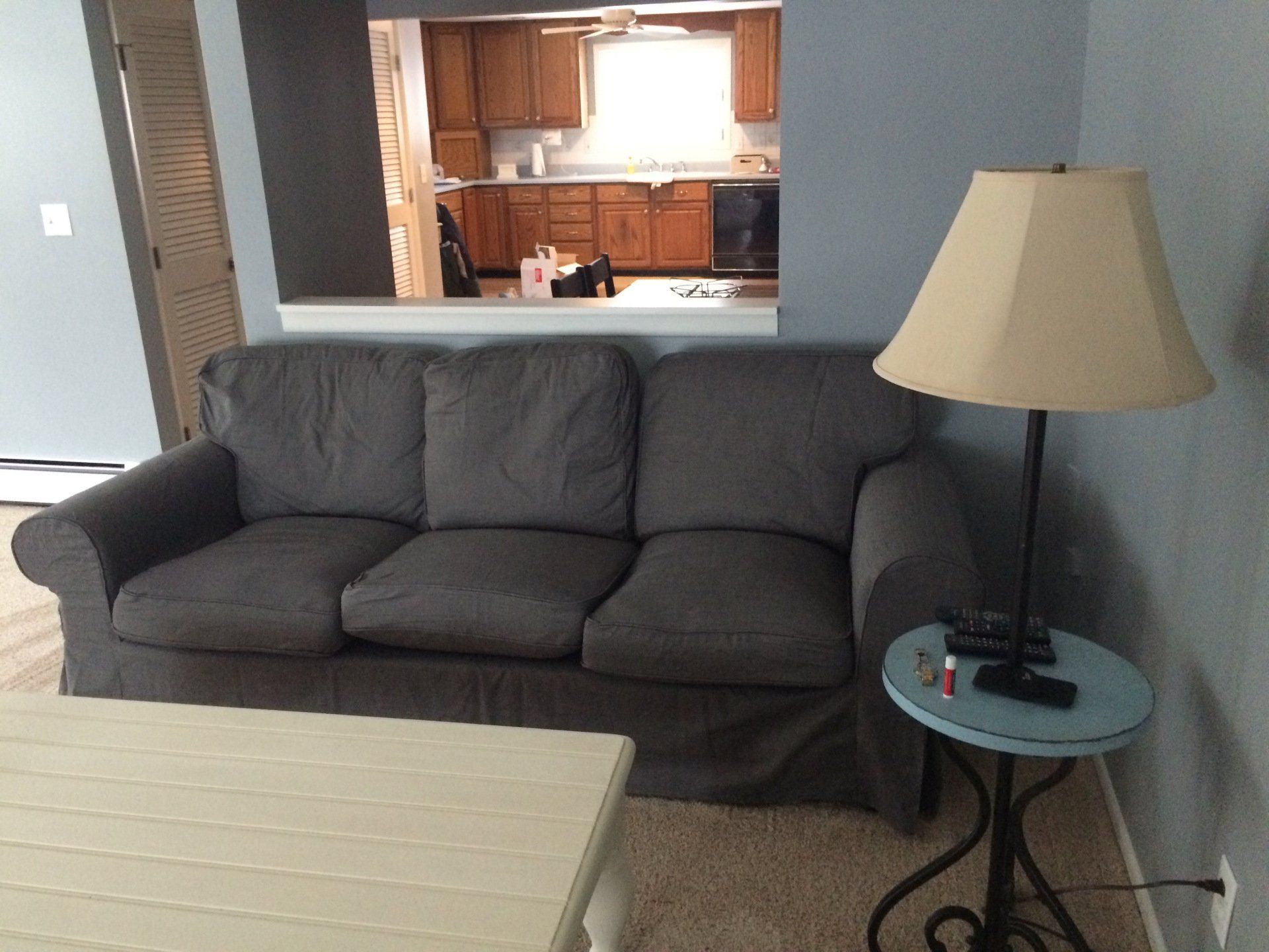 A living room with a couch and a lamp