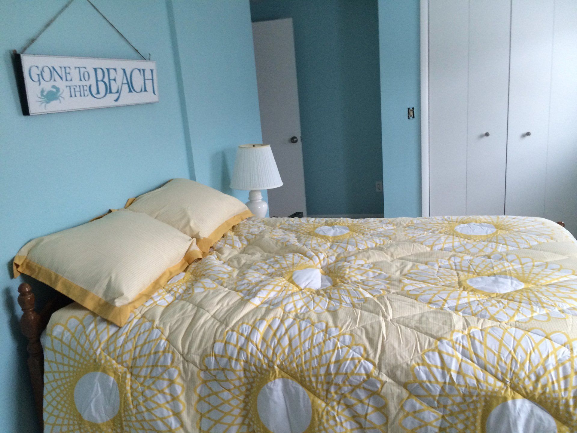 A bedroom with a bed and a sign that says going to the beach