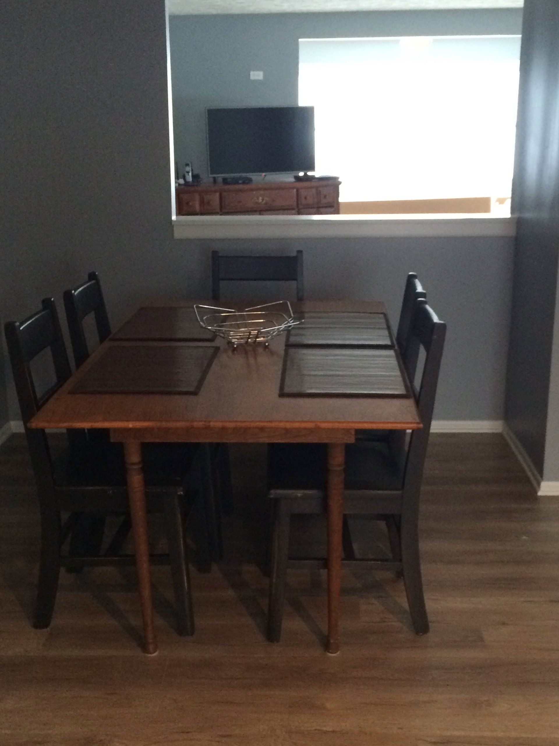 A dining room with a table and chairs and a television