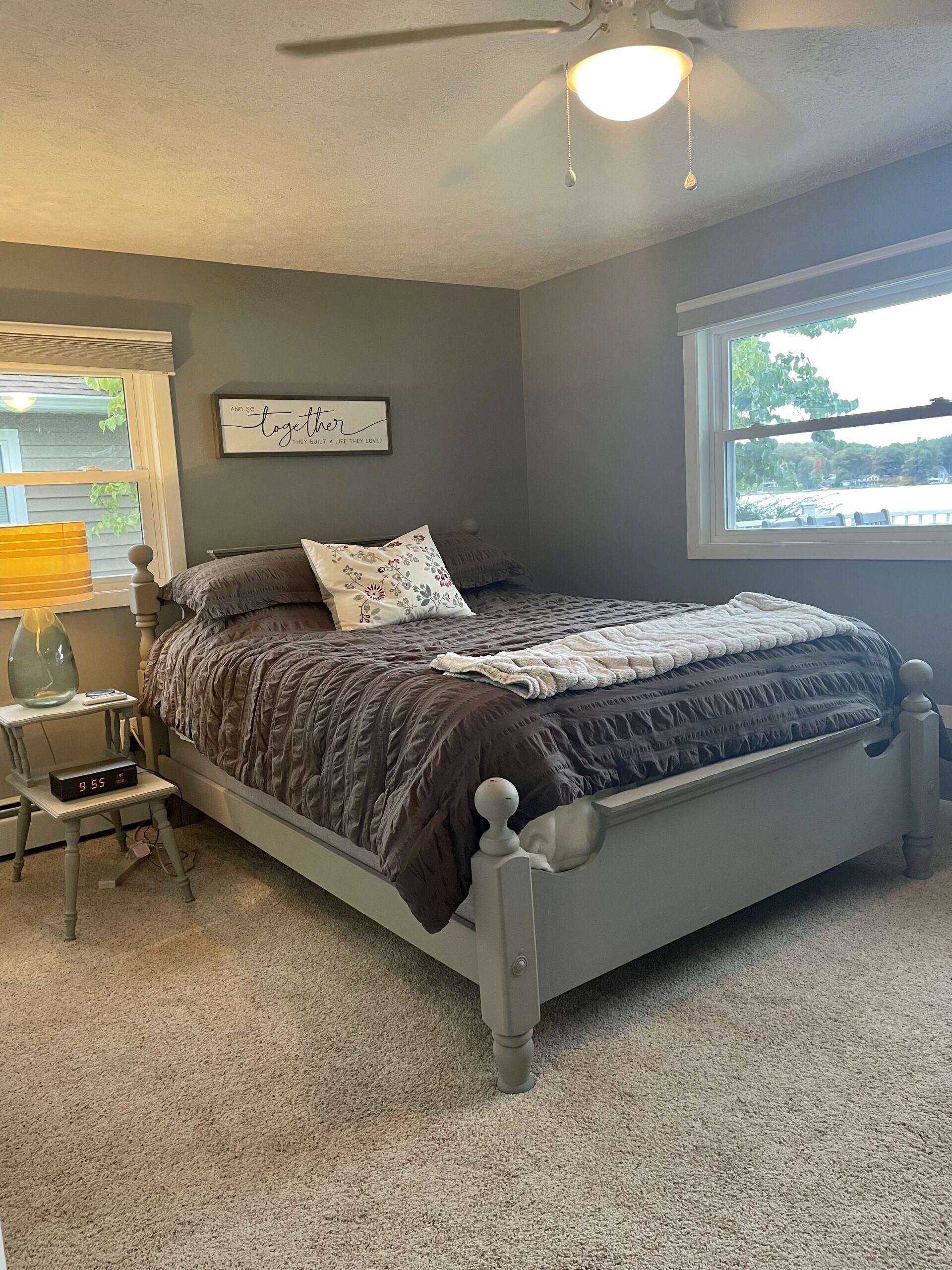 A bedroom with a bed and a ceiling fan.