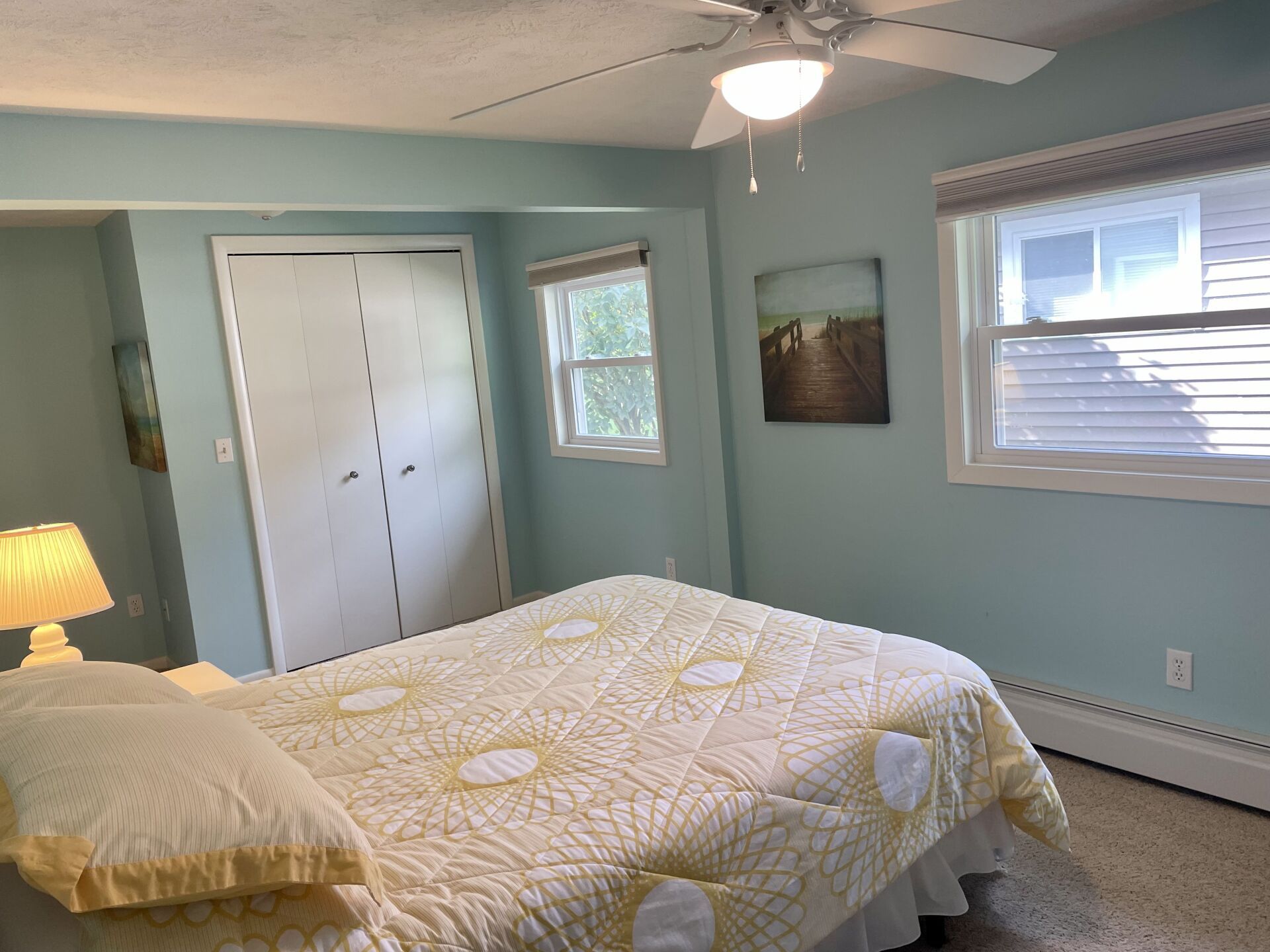 A bedroom with a king size bed and a ceiling fan.