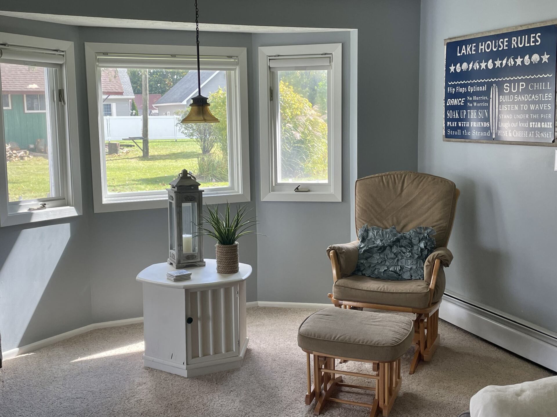 A living room with a rocking chair and ottoman
