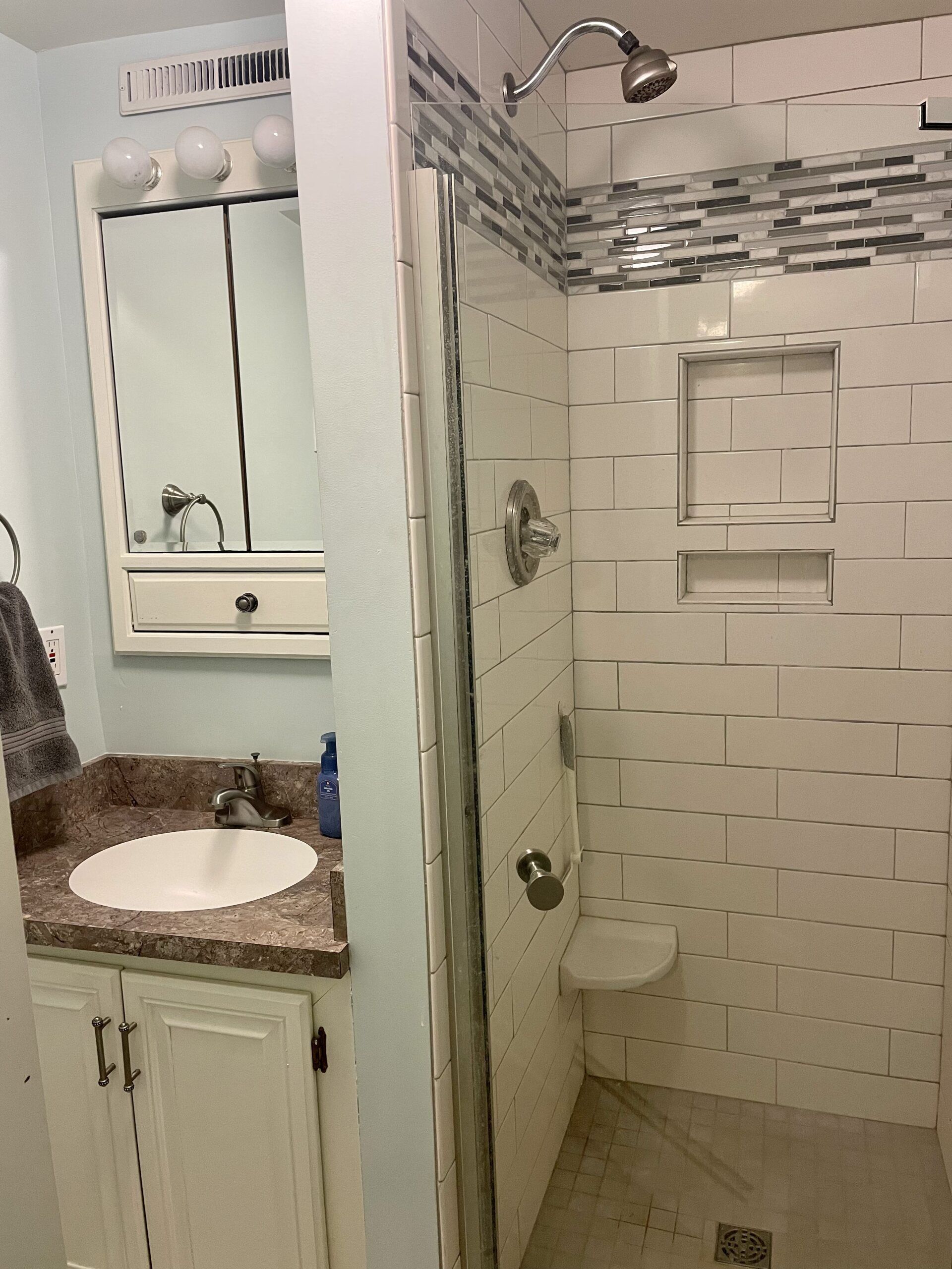 A bathroom with a sink, toilet, and shower.