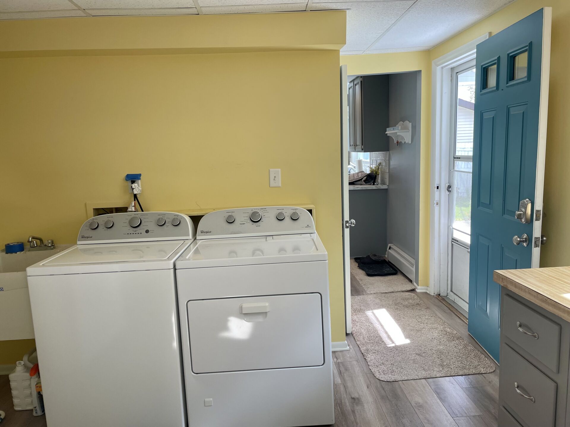 A laundry room with a washer and dryer and a blue door.