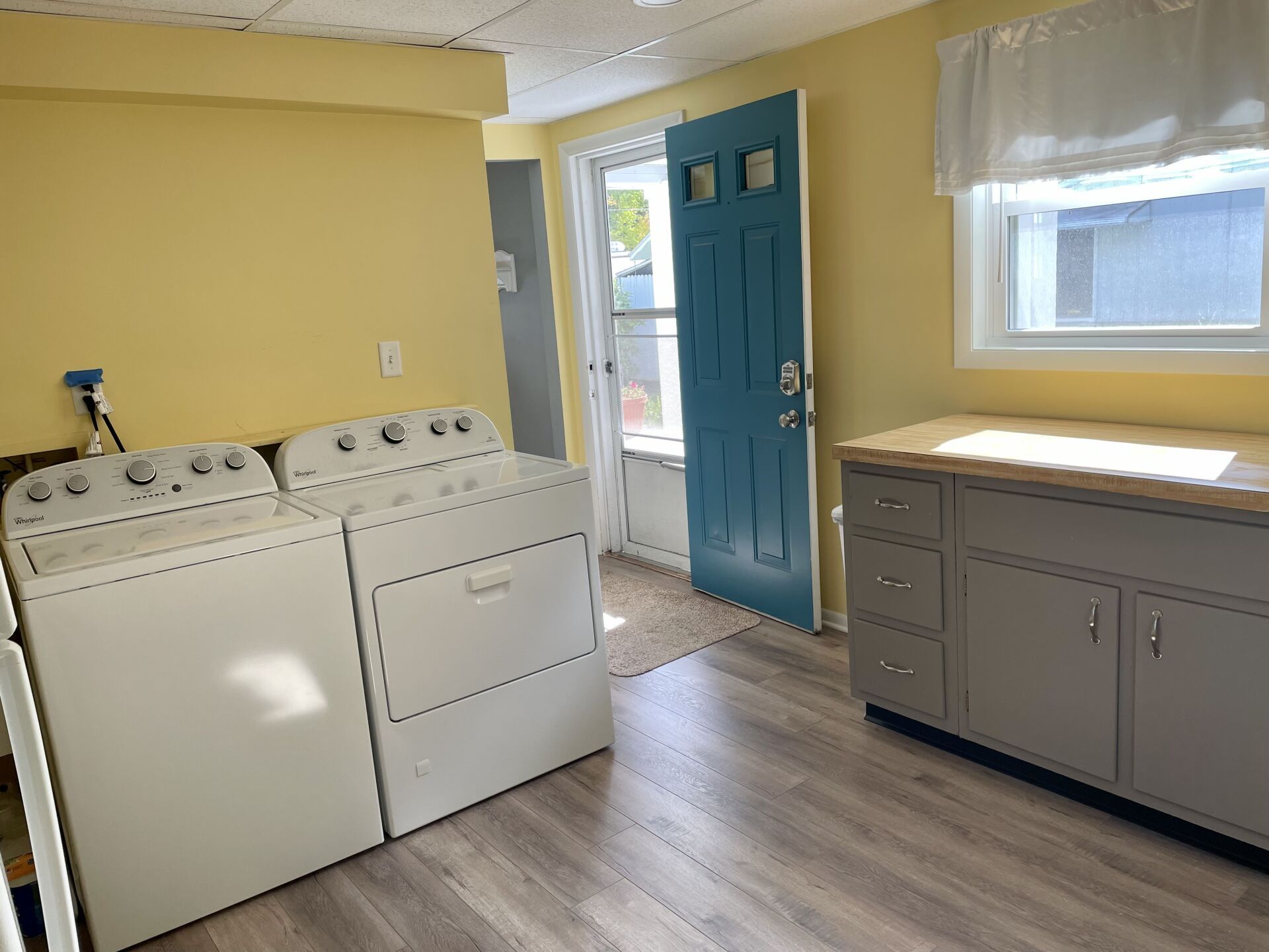 A laundry room with a washer and dryer and a blue door.