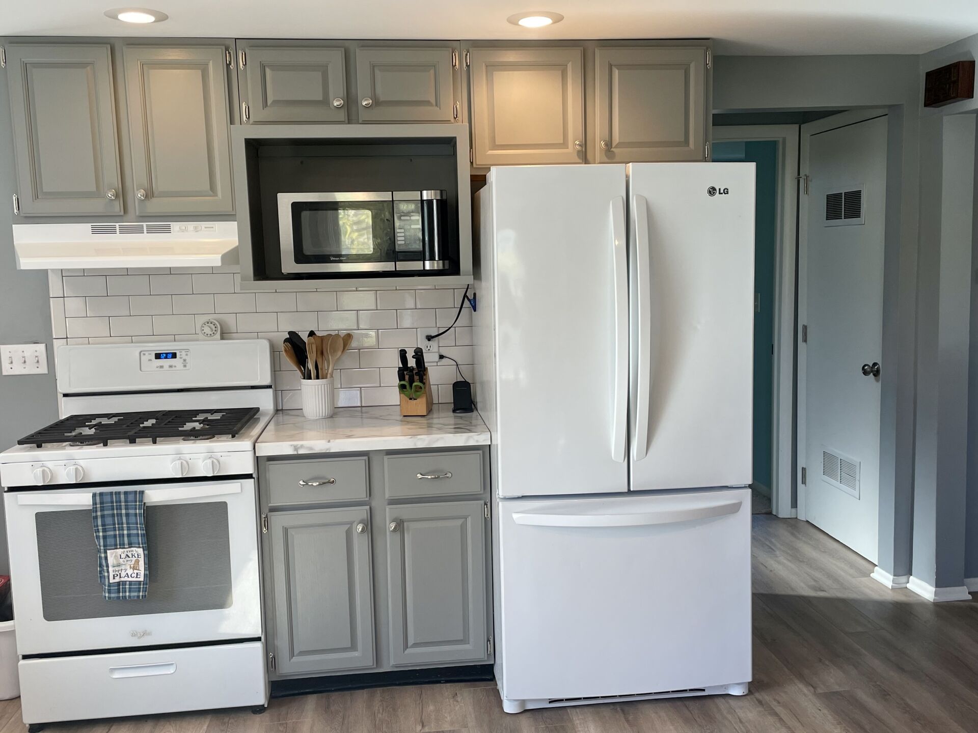 A kitchen with a stove, a refrigerator, and a microwave