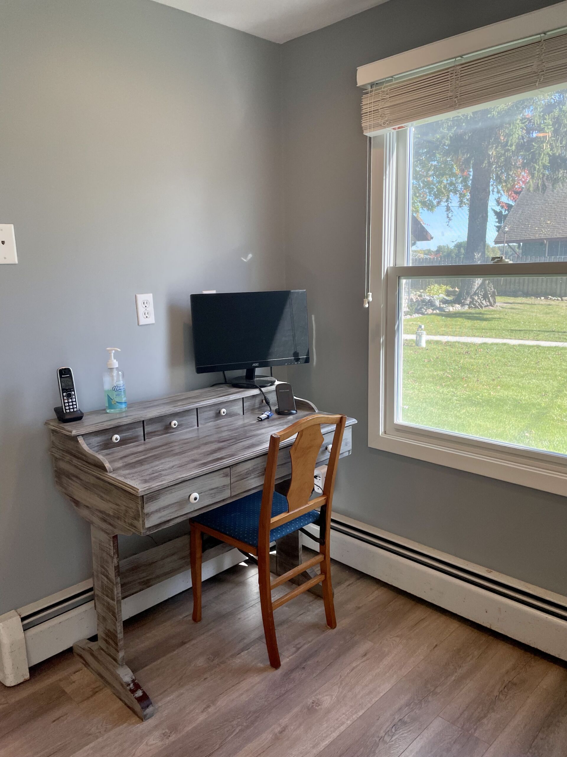 A room with a desk and chair and a computer on it.