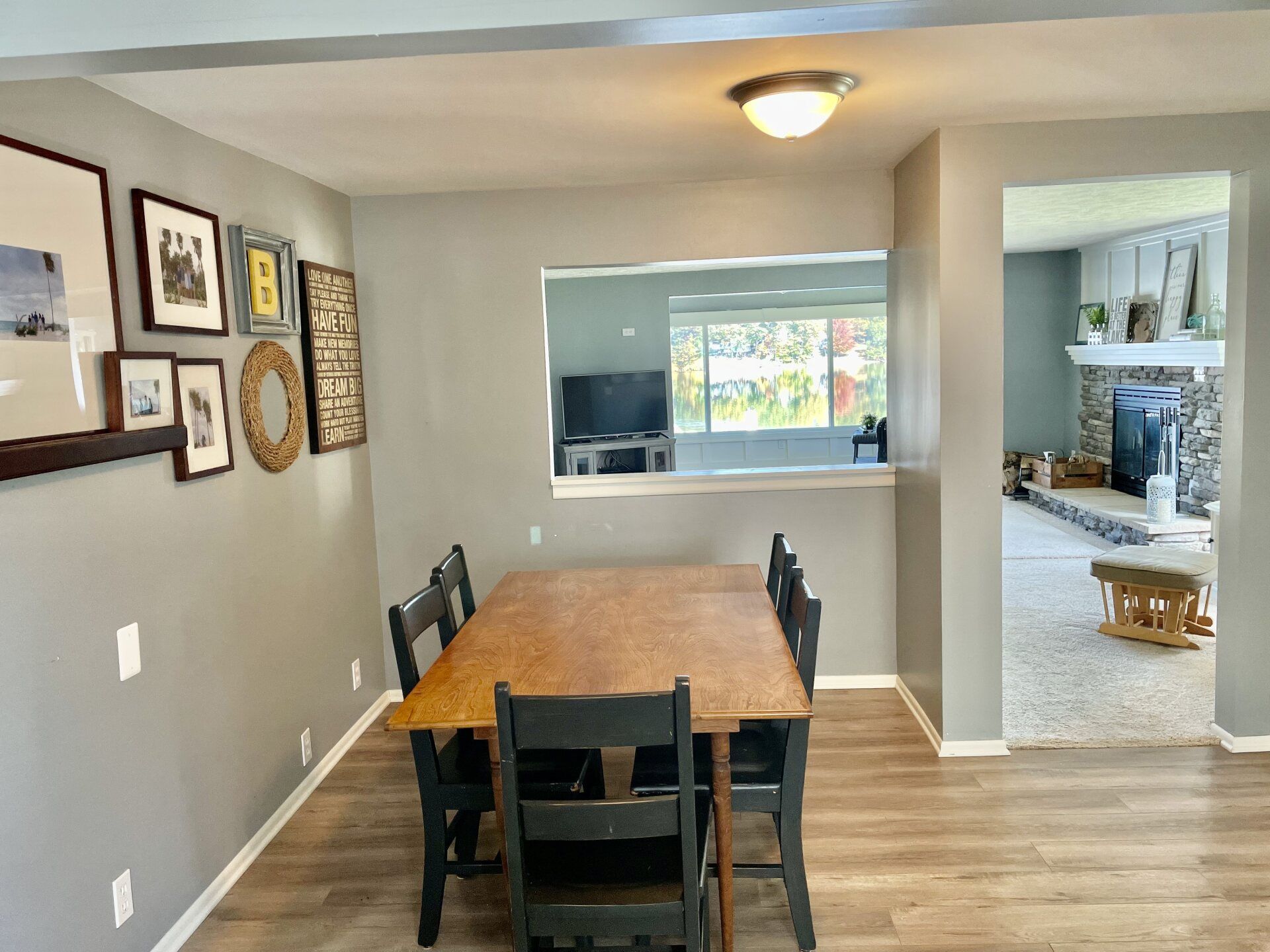 A dining room with a wooden table and chairs and a fireplace.