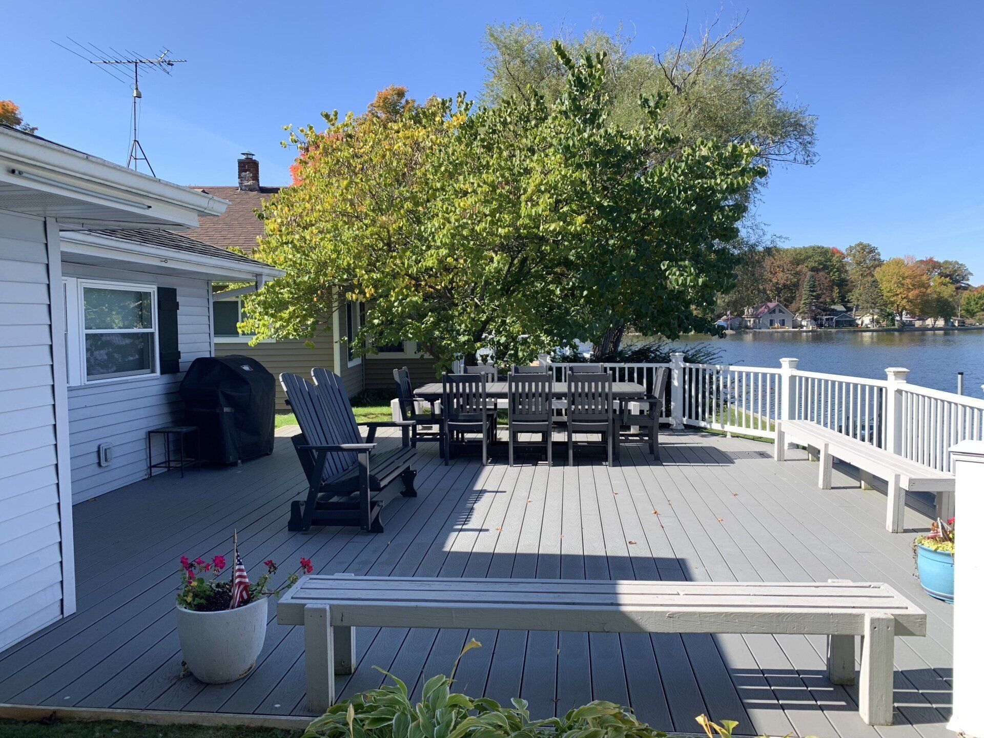 There is a large deck with a table and chairs on it.