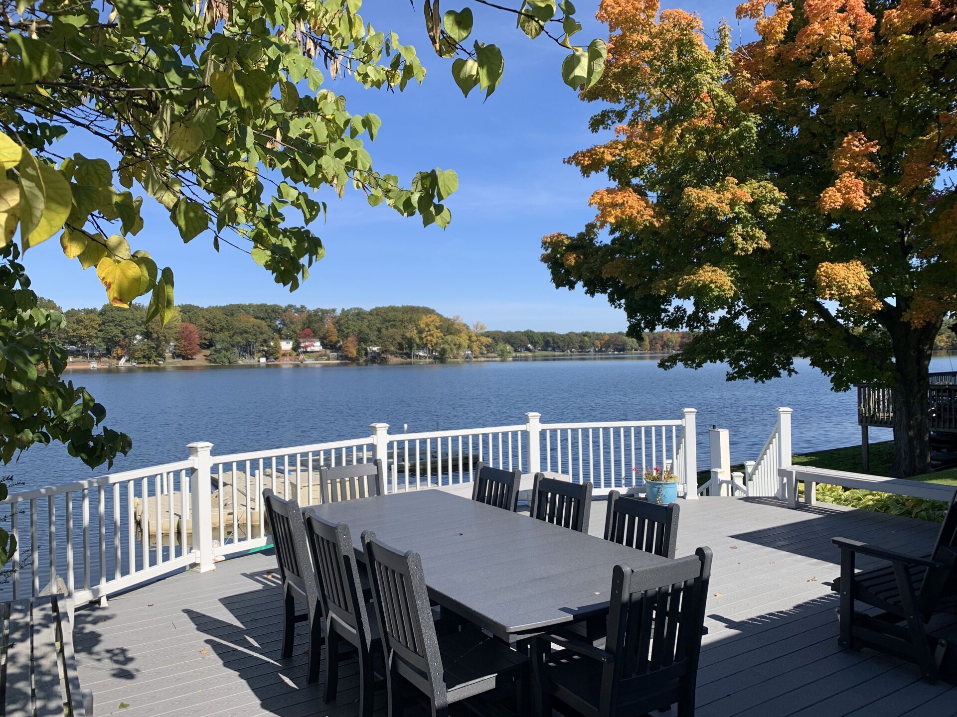 A table and chairs on a deck overlooking a lake