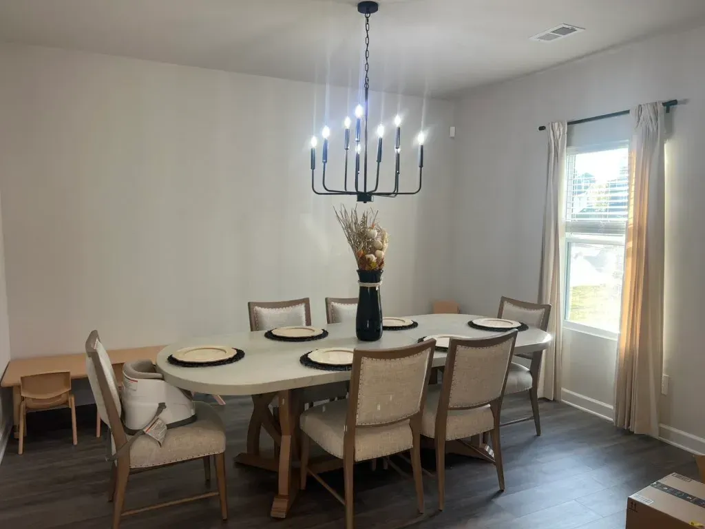 A dining room with a table and chairs and a chandelier.