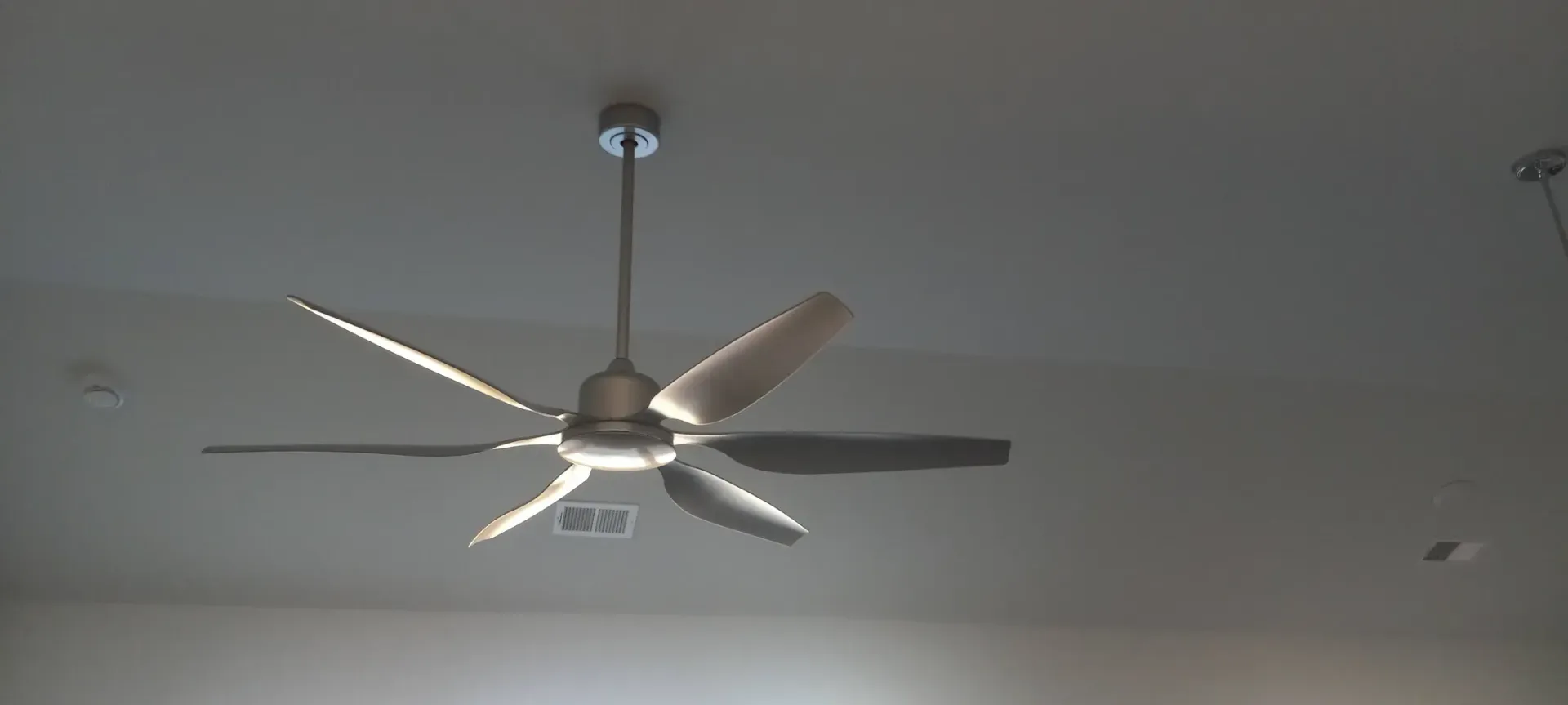 A ceiling fan is hanging from the ceiling of a room.