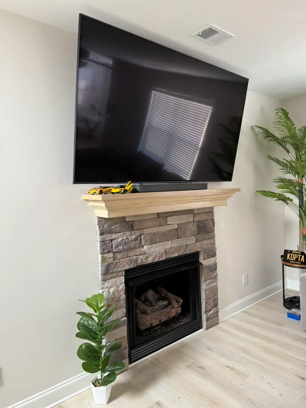 A living room with a fireplace and a flat screen tv mounted on the wall.