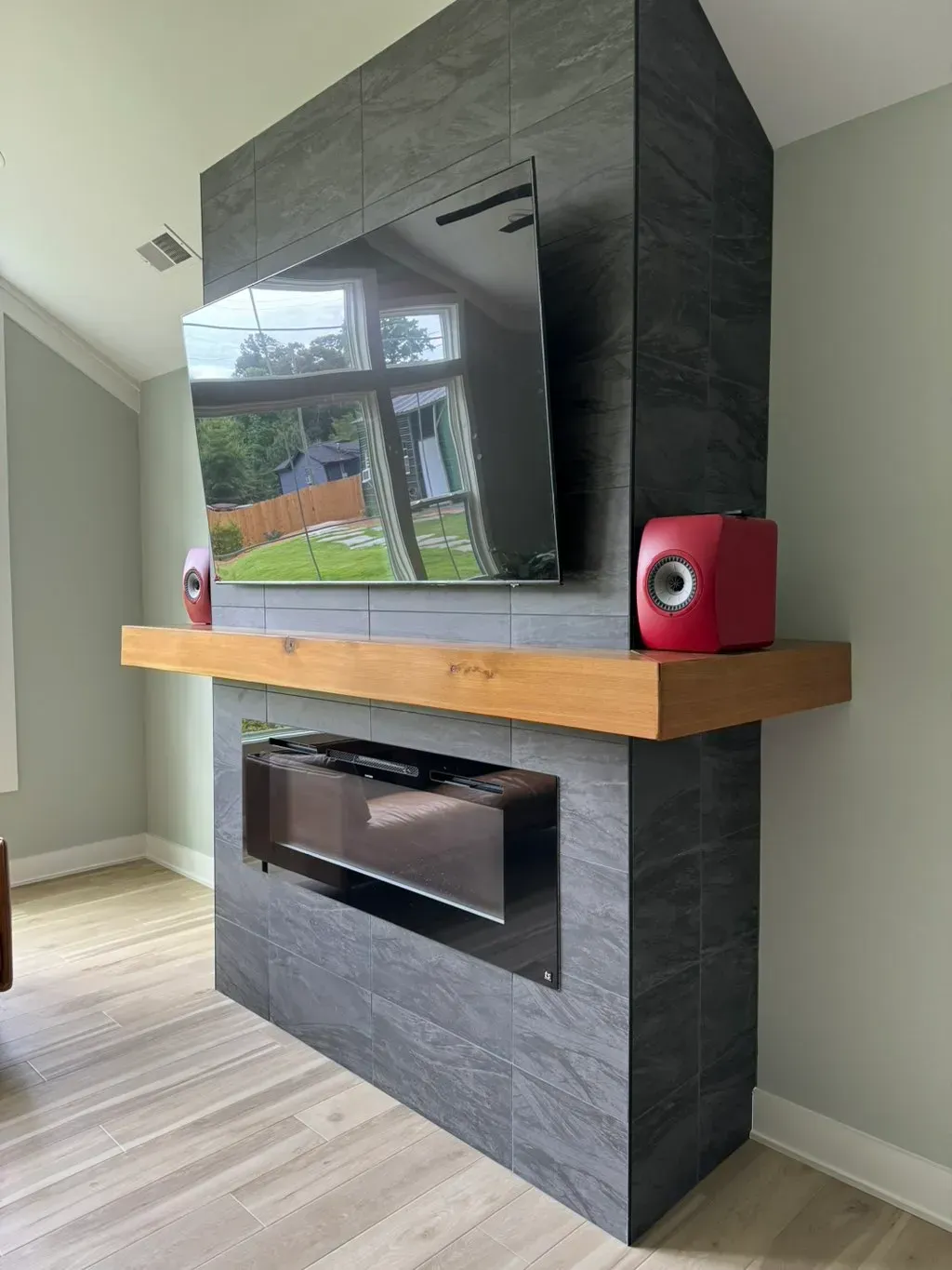 A living room with a fireplace , television and speakers.
