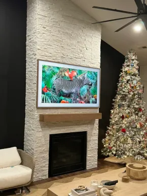 A living room with a fireplace and a christmas tree.