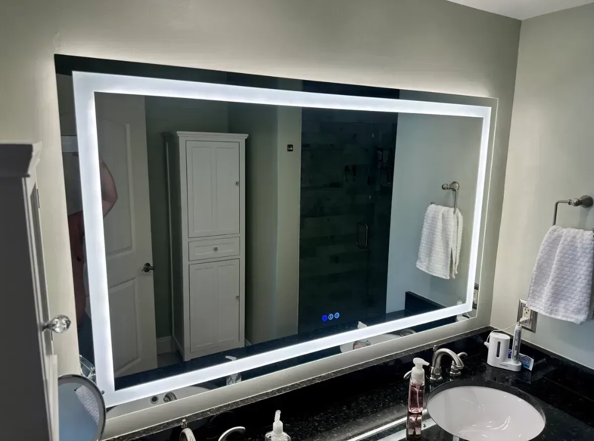 A bathroom with a large mirror and a sink.