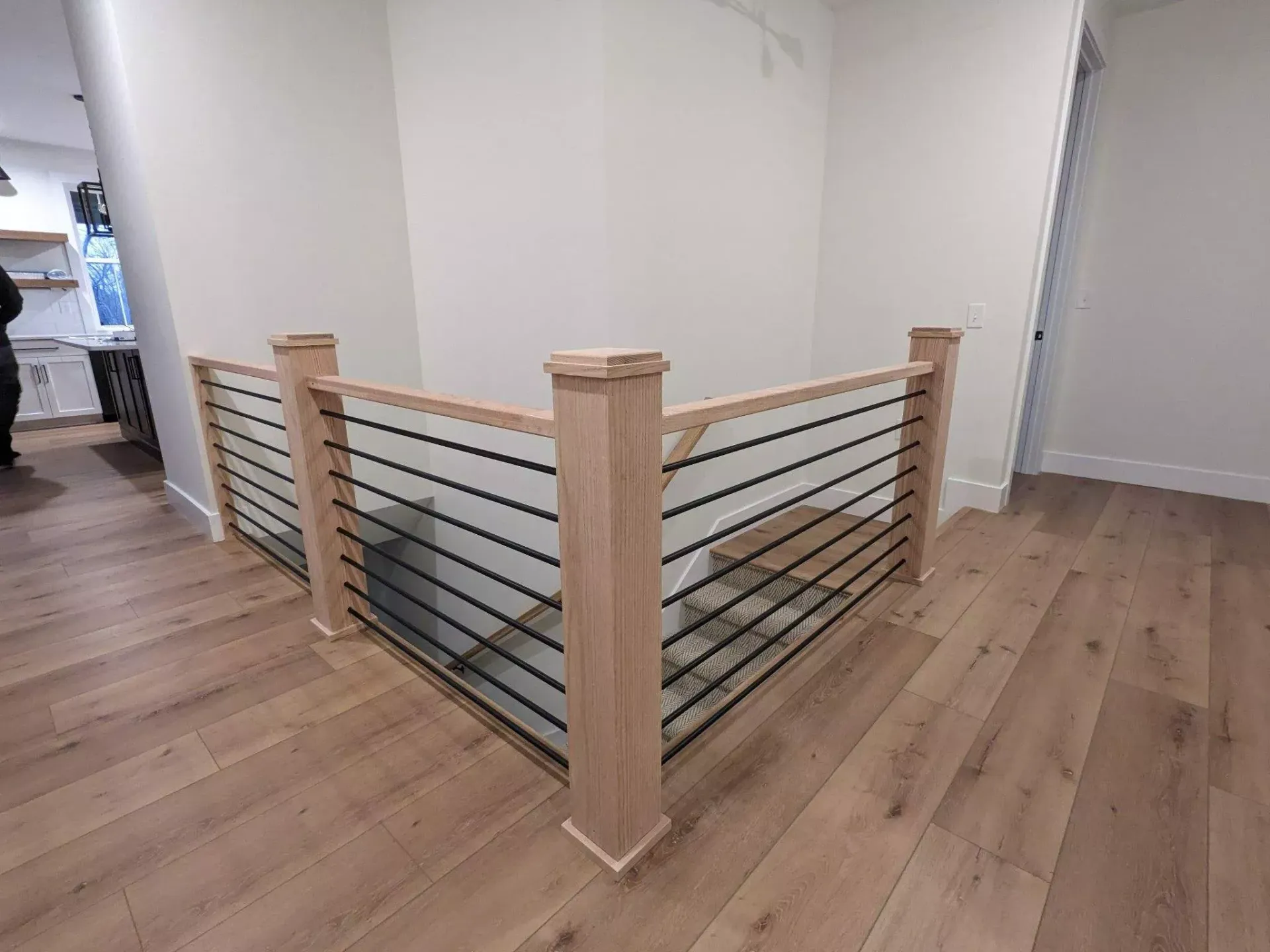 A wooden staircase with a glass railing in a house.