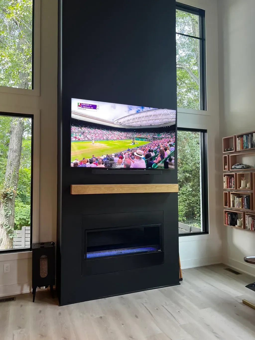 A living room with a fireplace and a flat screen tv on the wall.