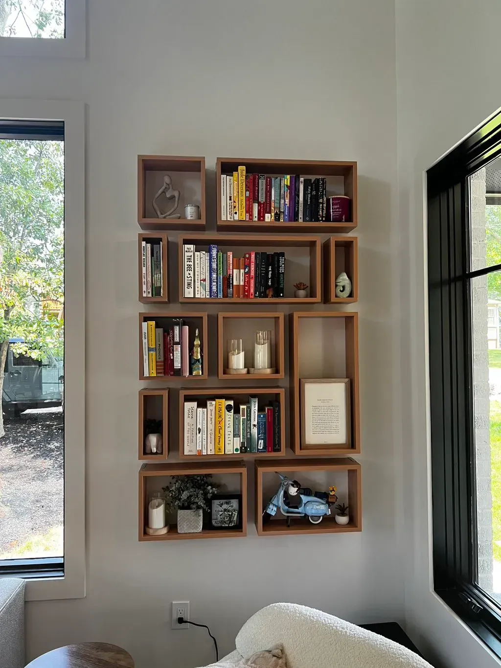 A living room with a bookshelf filled with books and a window.