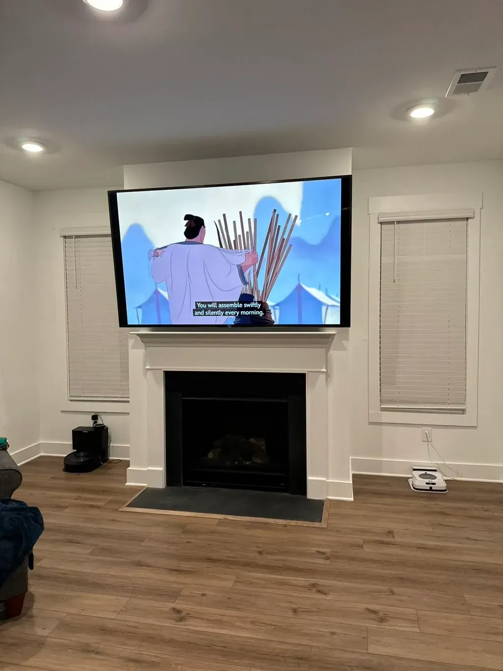 A living room with a fireplace and a flat screen tv.