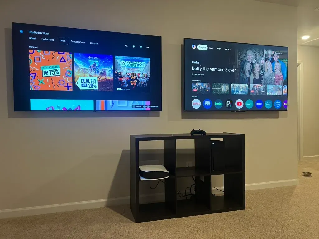 Two flat screen tvs are hanging on a wall in a living room