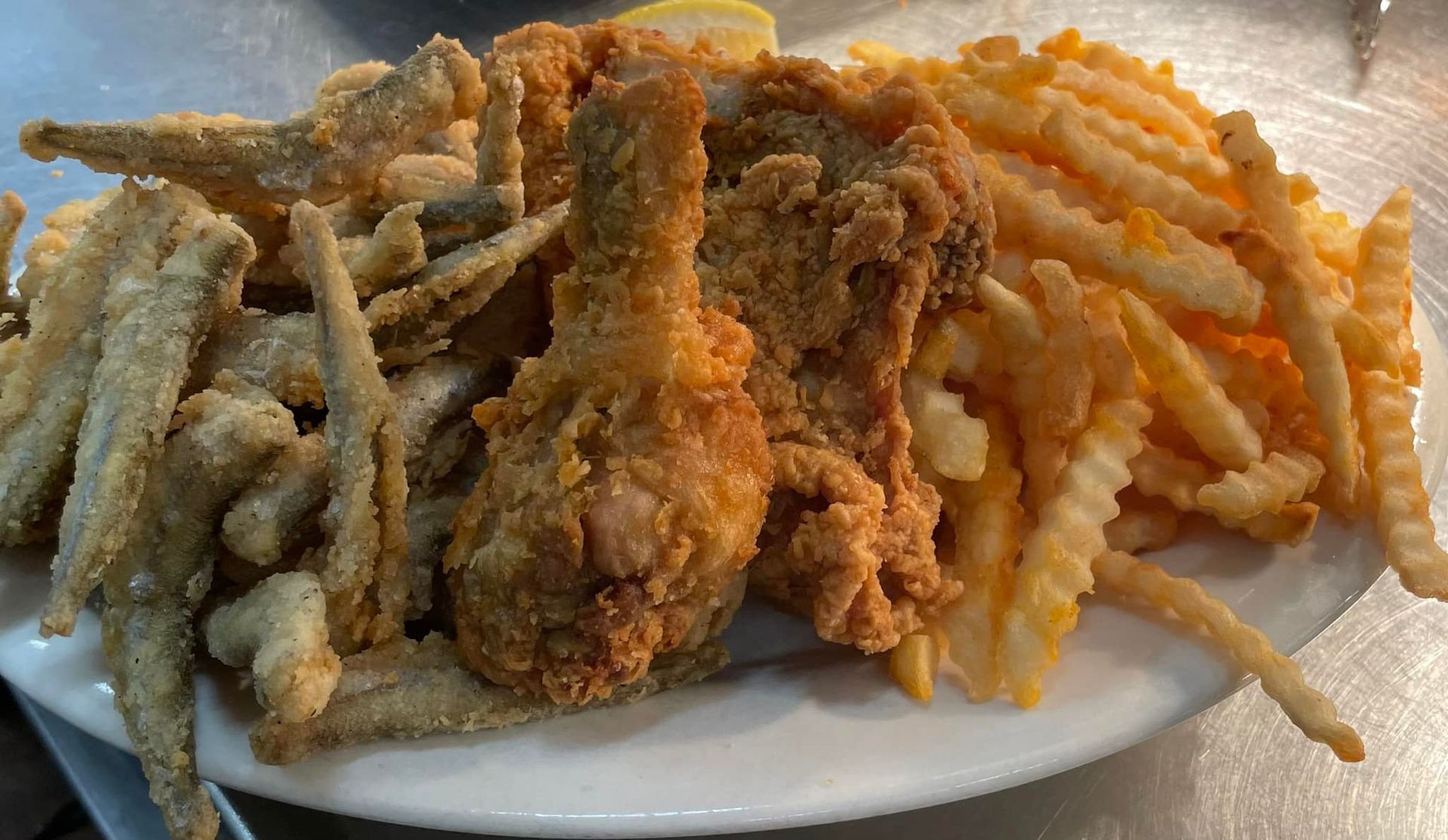 A plate of fried fish and french fries on a table.
