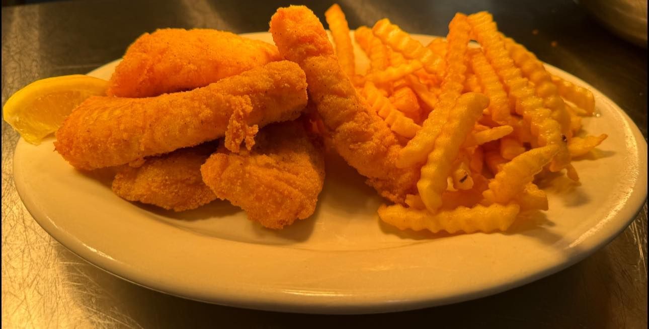 A plate of fried fish and french fries on a table.