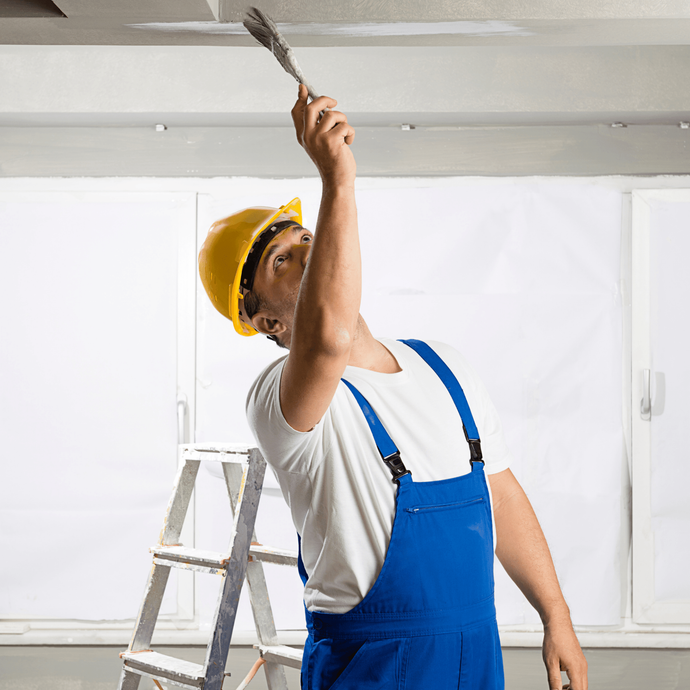 Worker painting the ceiling