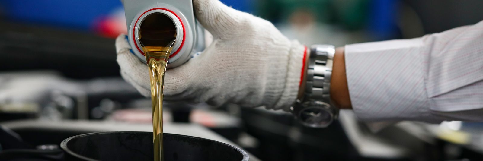 A person is pouring oil into a car engine.