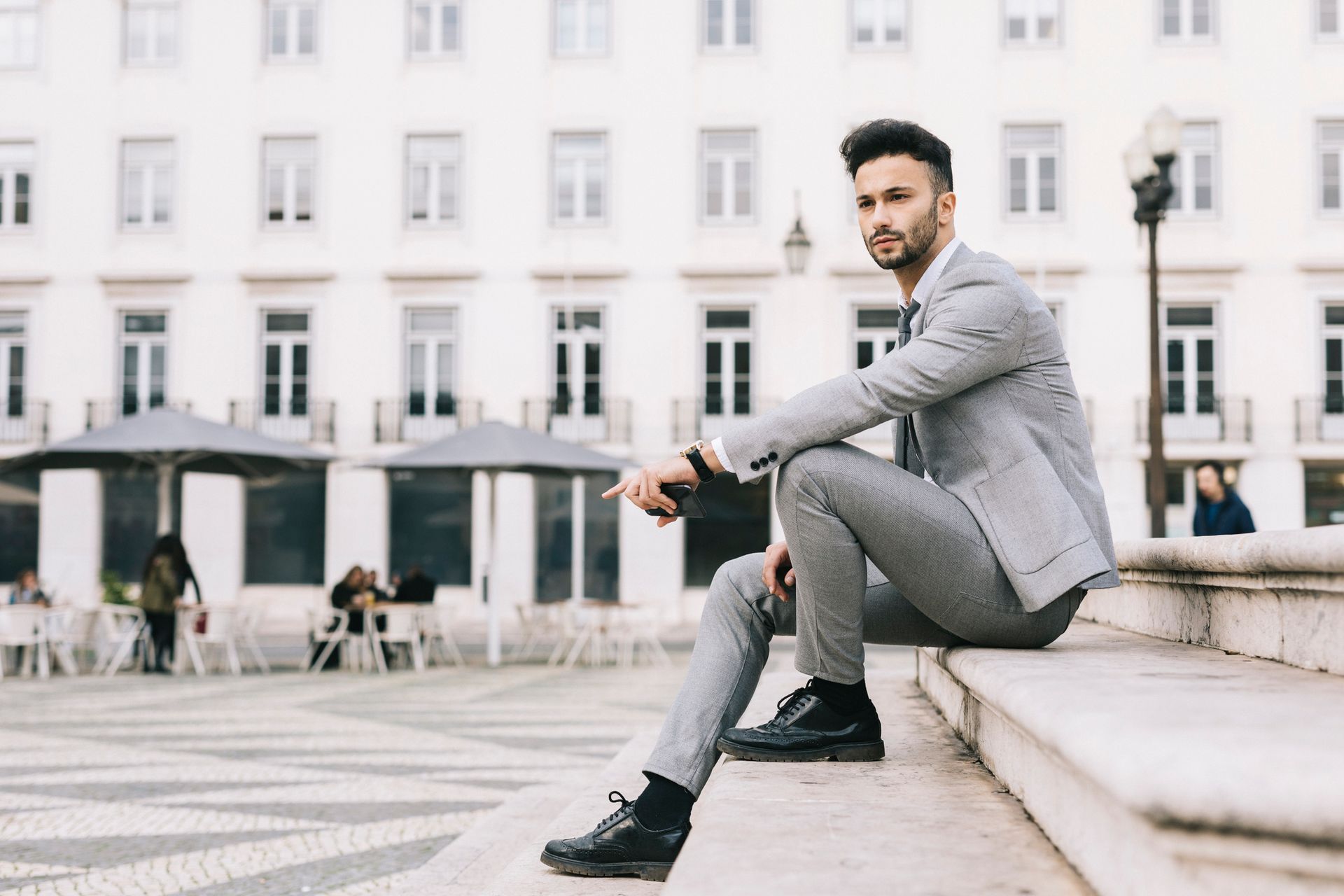 Uomo con completo grigio seduto sulla scalinata di una chiesa