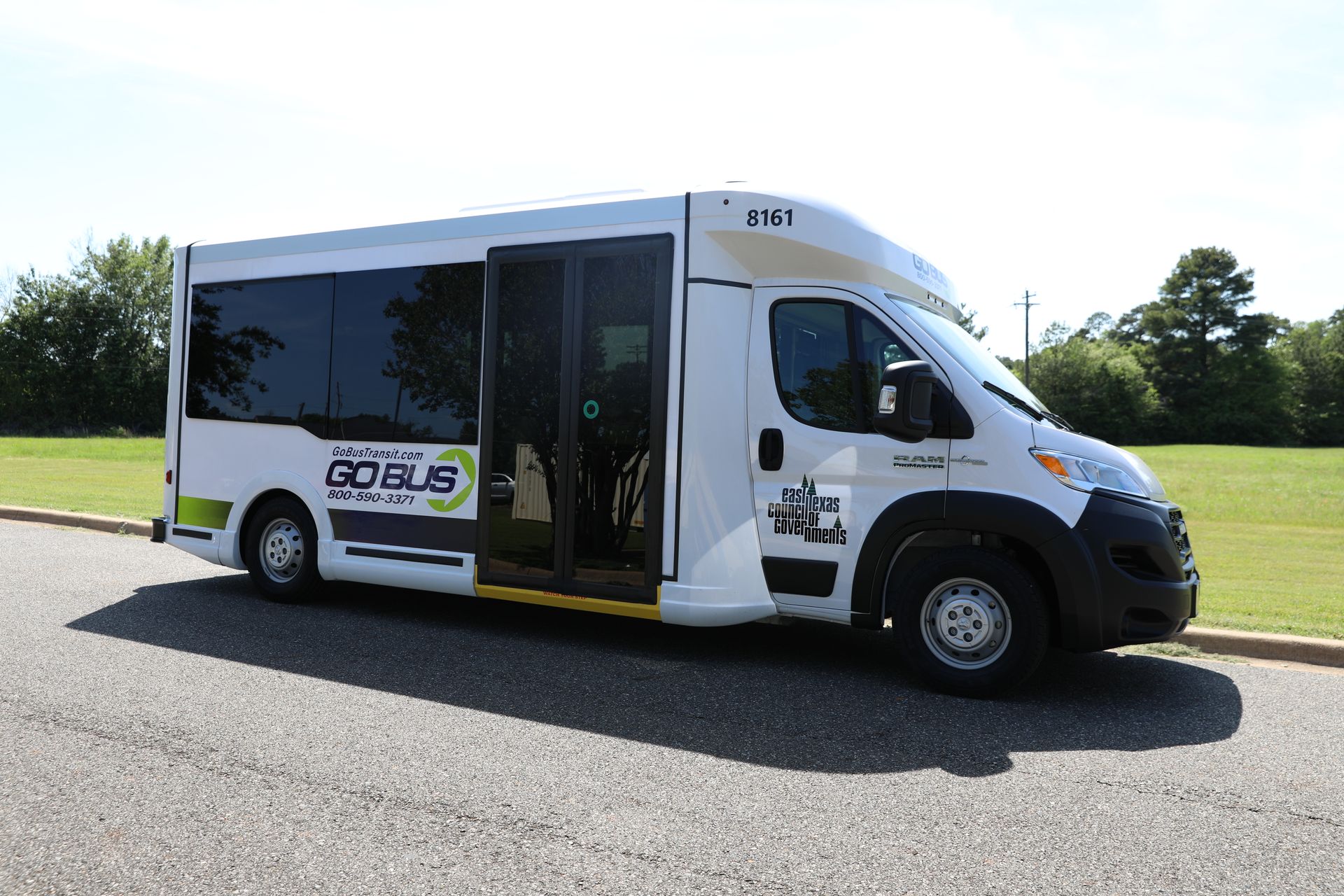A white van with the door open is parked on the side of the road.