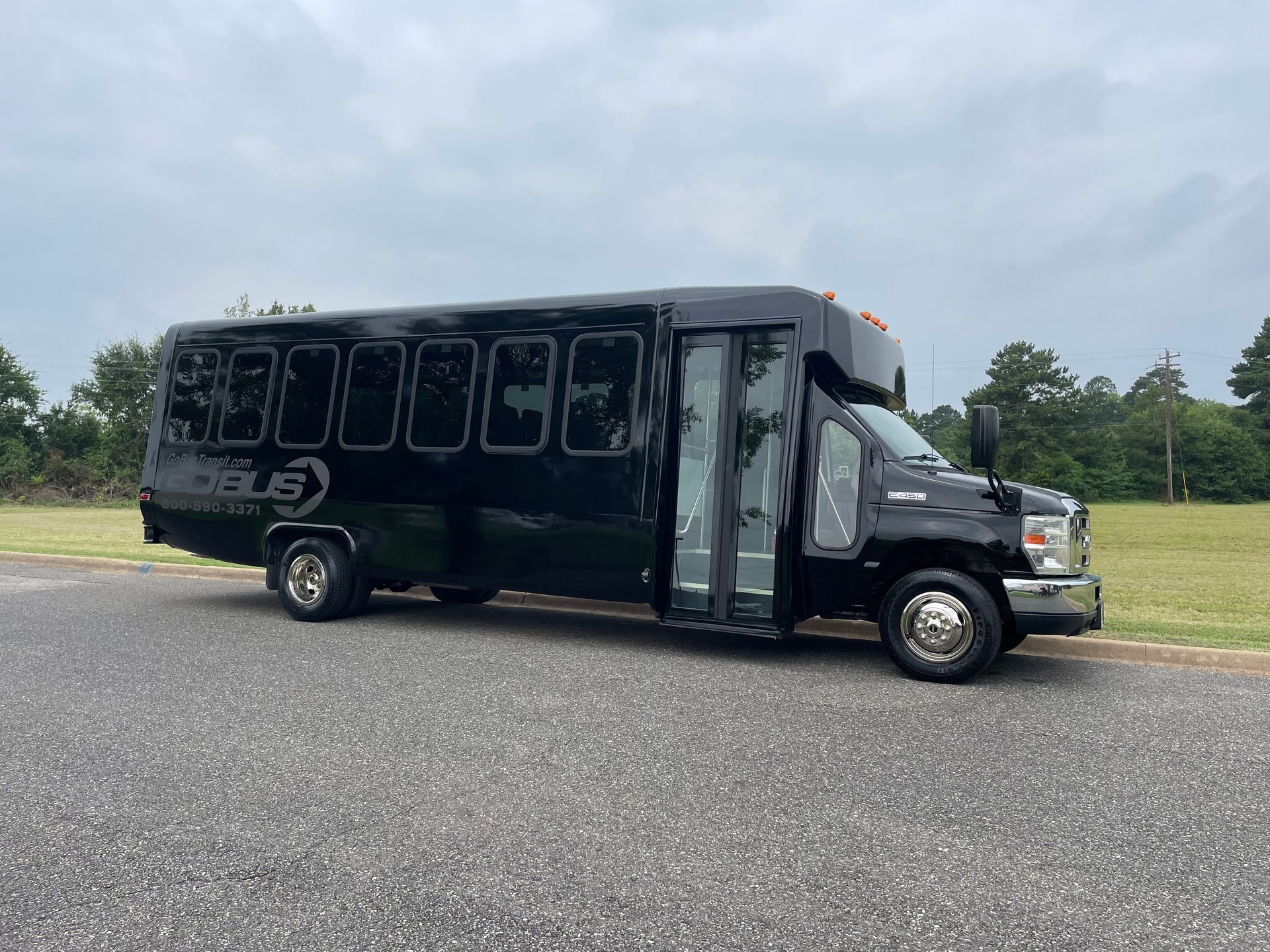 A black bus is parked on the side of the road.