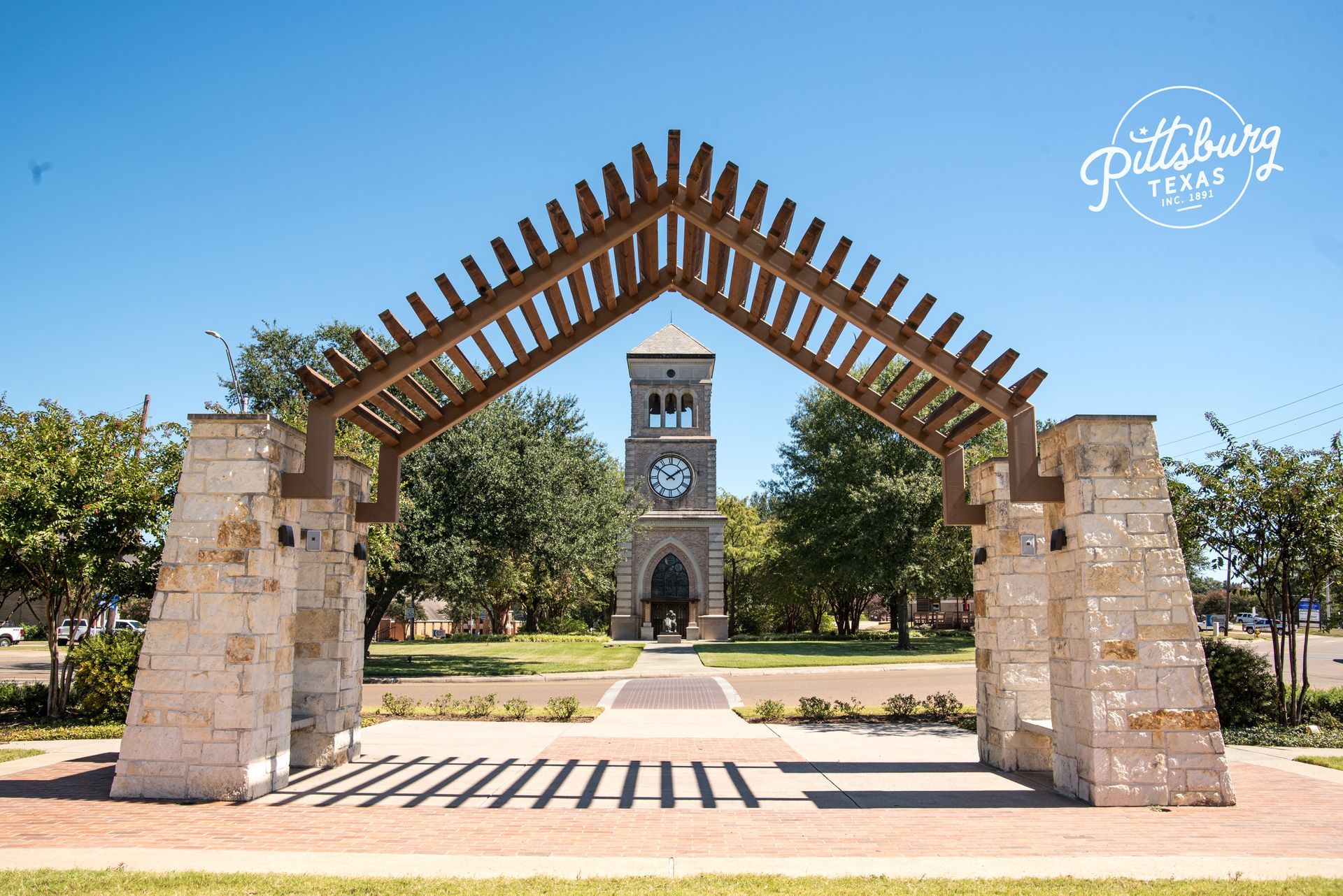 A large stone archway with a clock tower in the background.