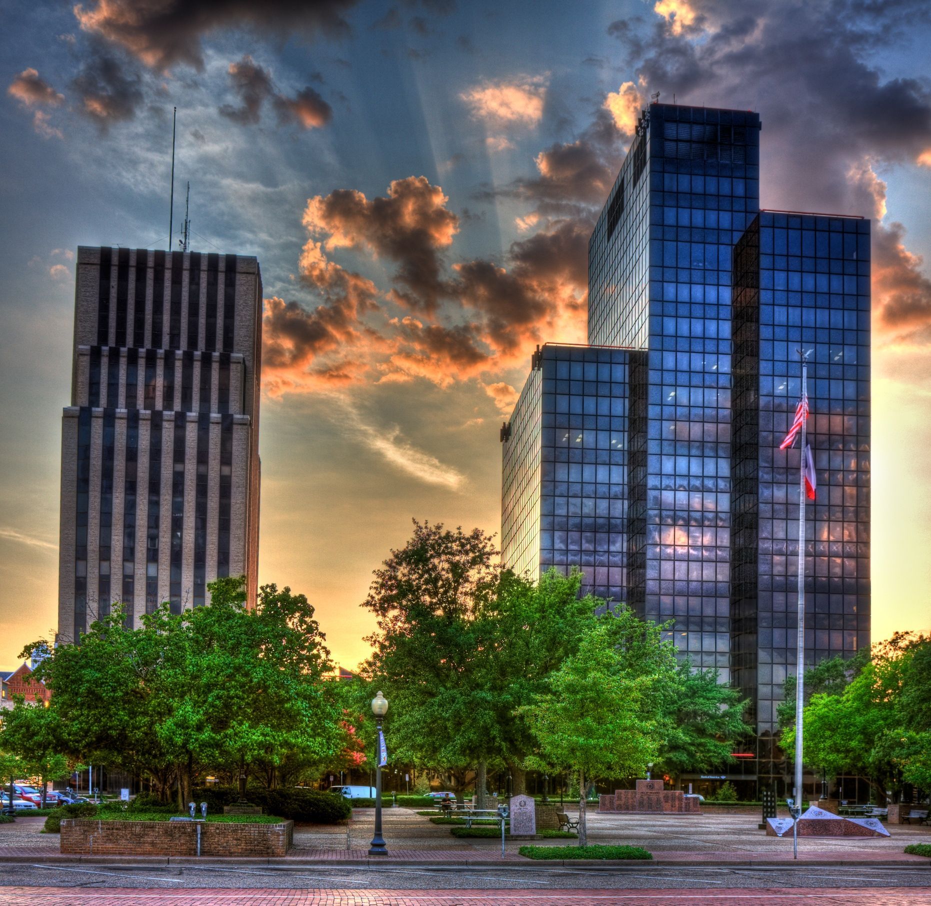 A sunset over a city with tall buildings and trees