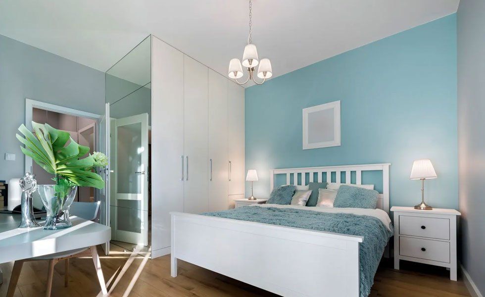 Stylish bedroom with mirror wall in pastel colors