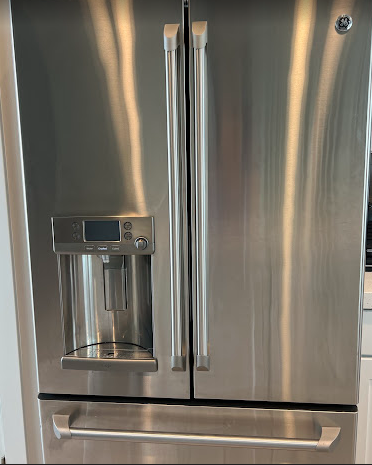 A stainless steel refrigerator with a water dispenser