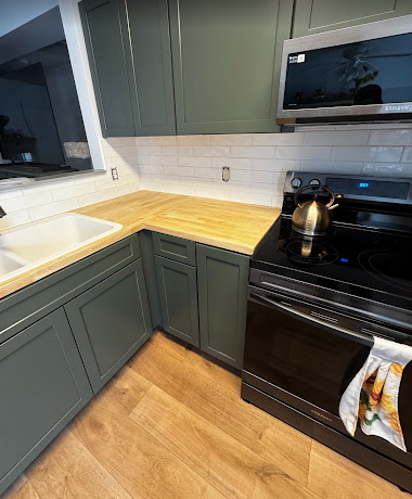 A kitchen with a stove , sink , and microwave.