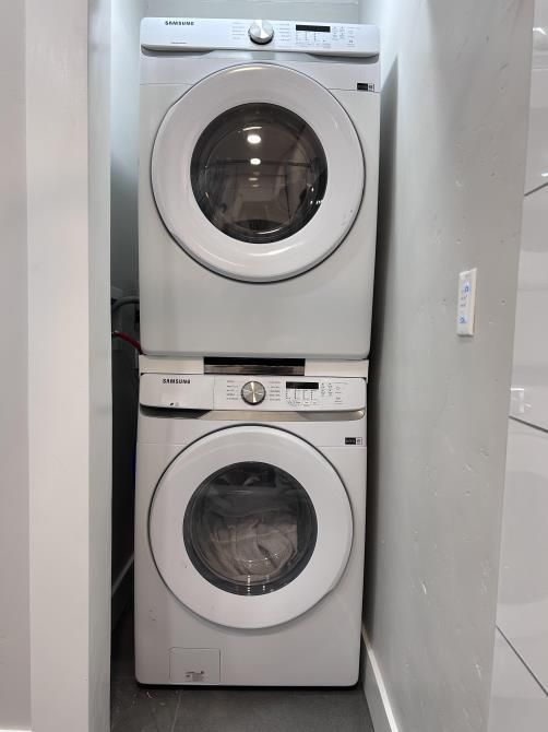 A washer and dryer are stacked on top of each other in a laundry room.