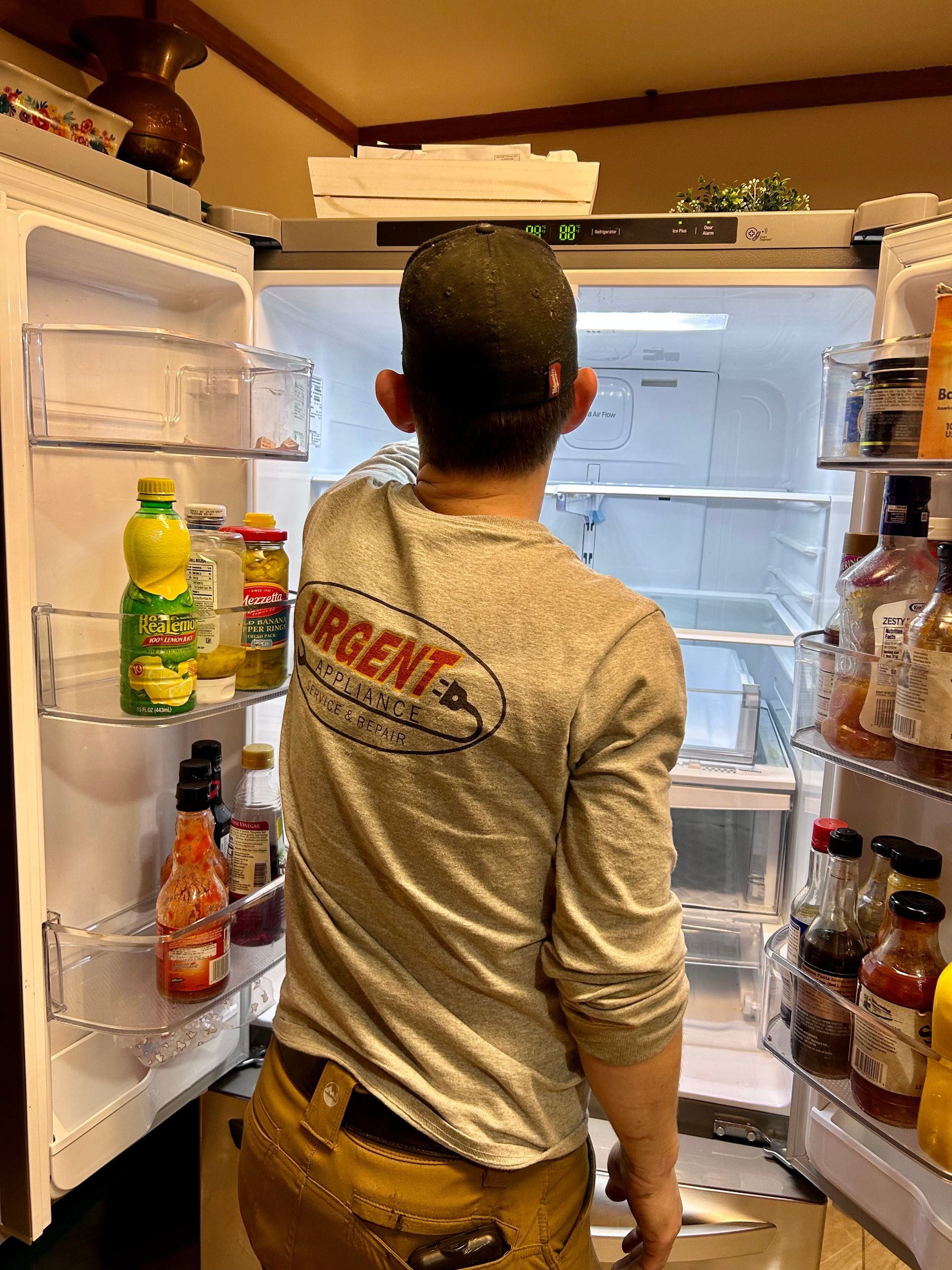 A man is standing in front of an open refrigerator.