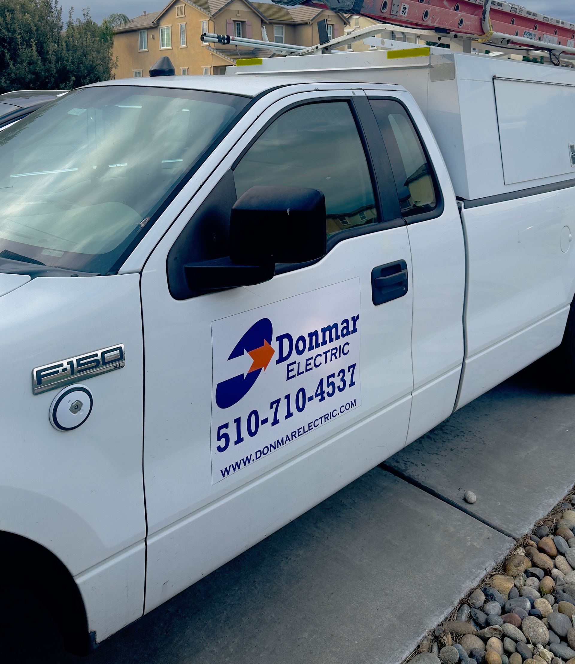 A white work truck parked on a street with 