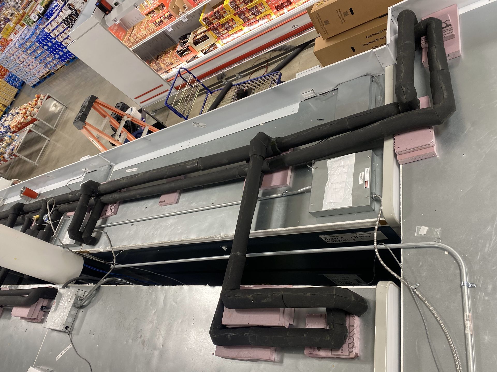 A bunch of pipes are hanging from the ceiling of a building.