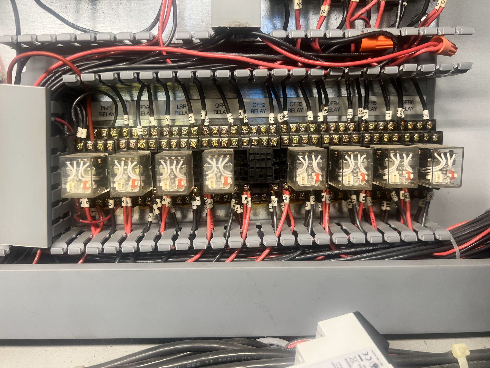 A close up of a electrical box with a lot of wires coming out of it.