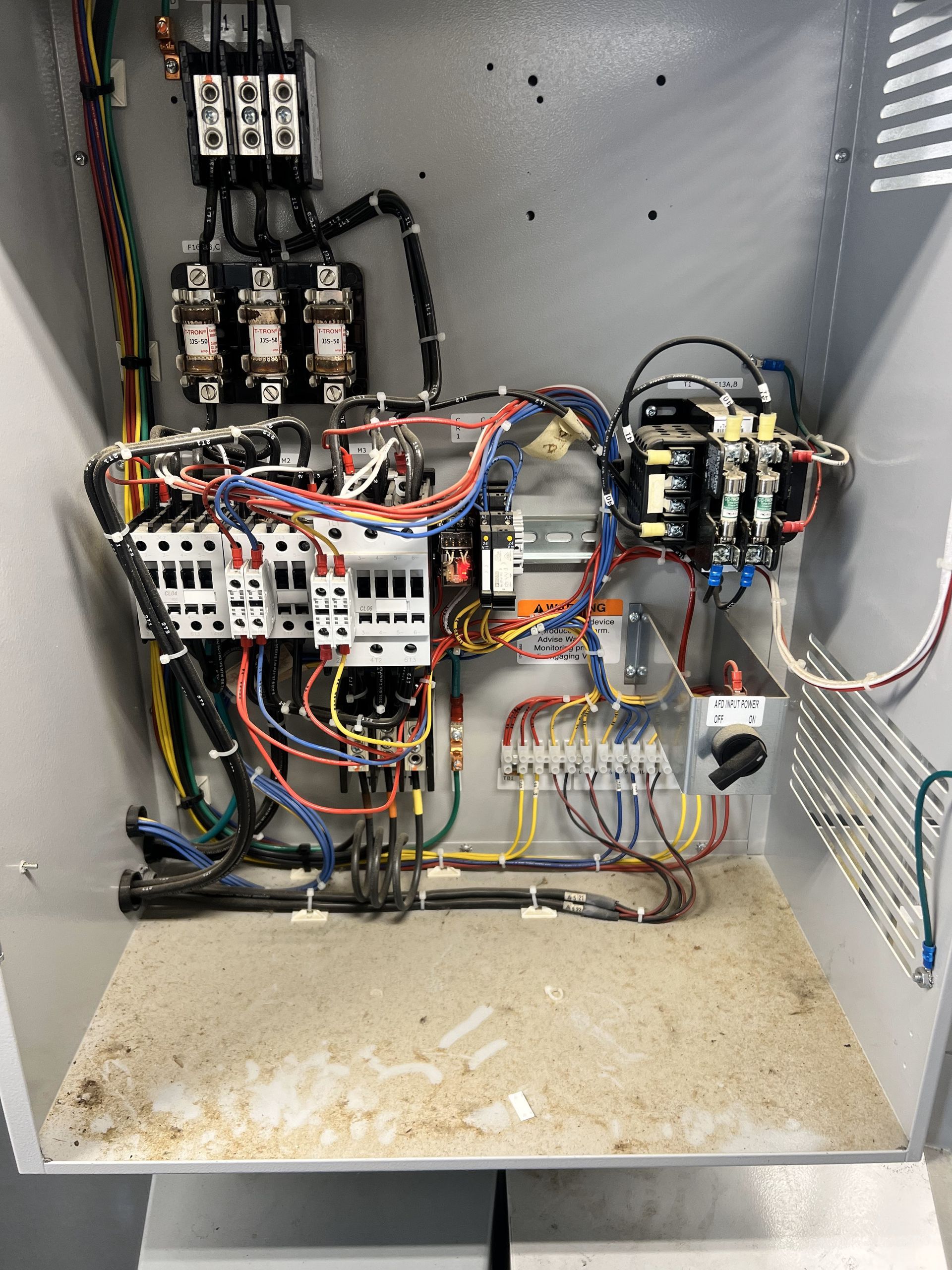 A dirty electrical box with a lot of wires coming out of it