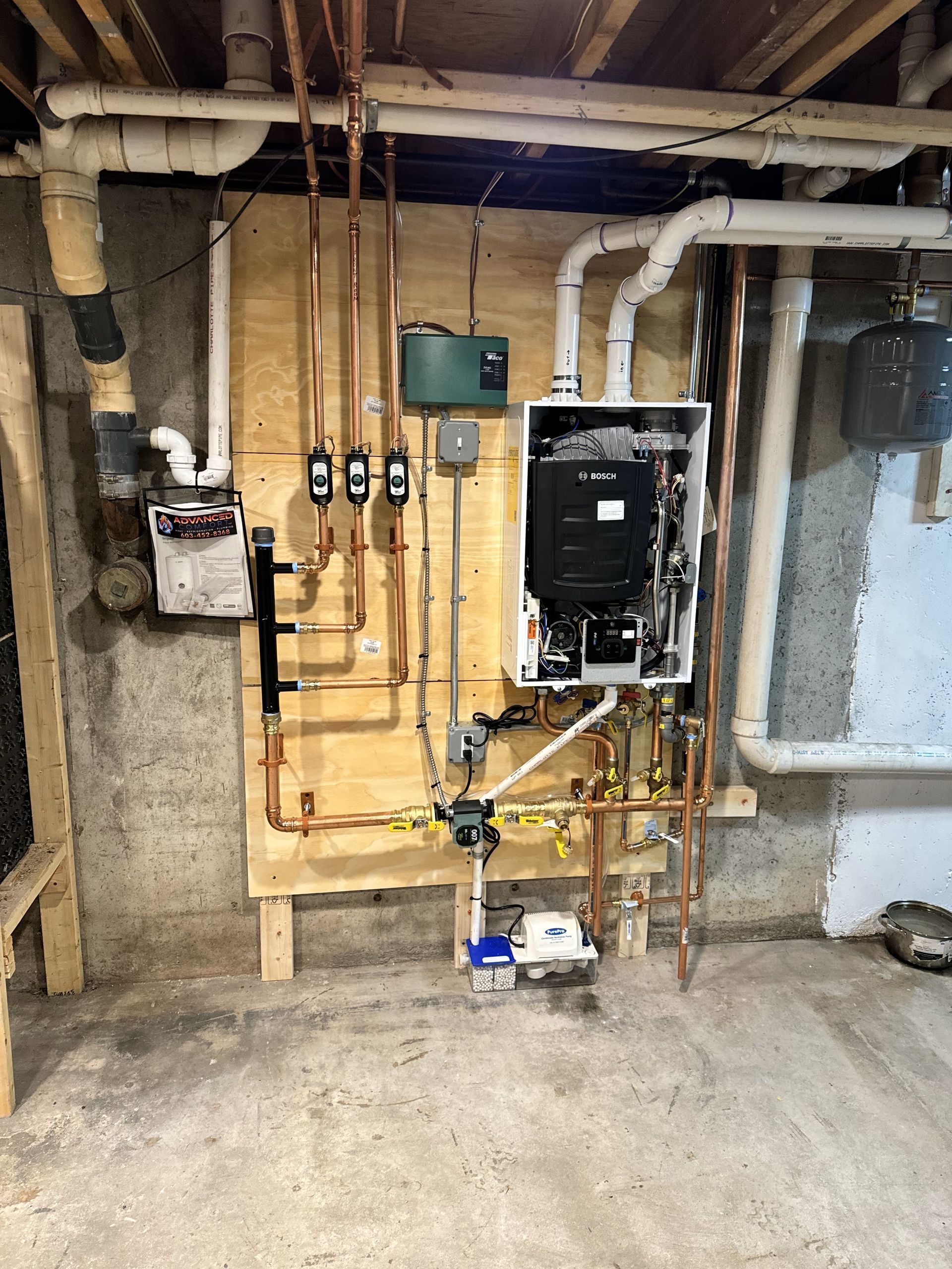 A boiler is being installed in a basement.