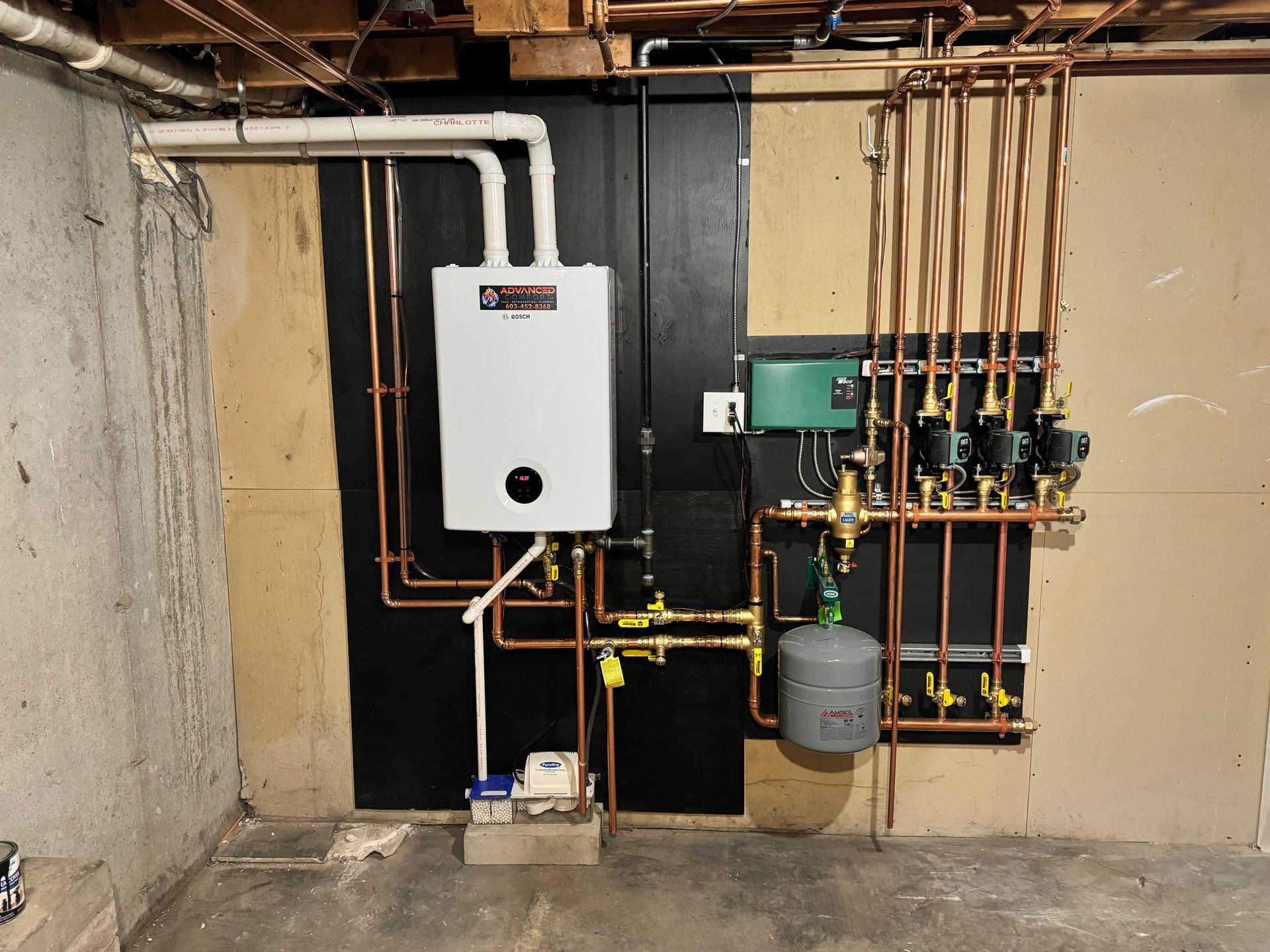 A white water heater is mounted to a wall in a basement.