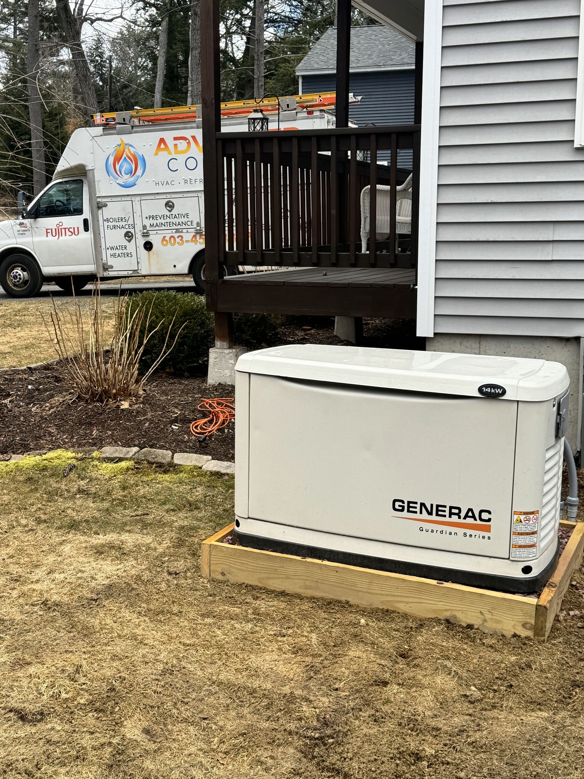 A generator is sitting in front of a house next to a van.